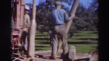 Sacramento California (1937): Man Wearing Blue Shirt Lowers Brown Object