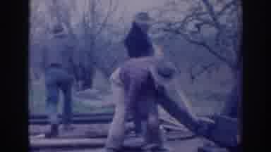 Sacramento California (1937): Man Wearing Tan Pants Places Brown Board On Ground