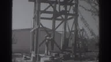 Sacramento California (1937): Man Wearing Tan Shirt Lifts Wood den Object On A