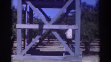 Sacramento California (1937): Man Wearing White Shirt Climbs Up Blue Wooden Tower