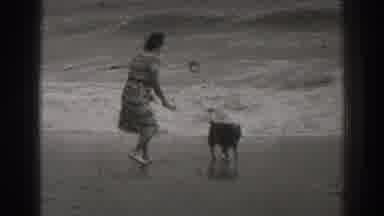Santa Cruz California (1937): Woman And Her Dog Running On The Beach