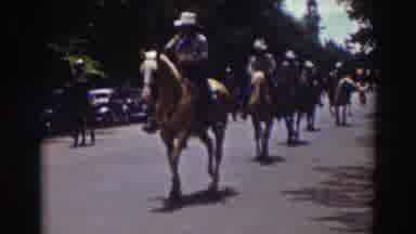 Truckee California (1937): People Wearing Blue Yellow And White Costumes Ride
