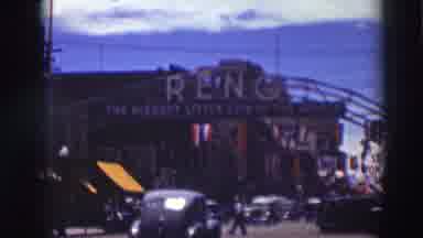 Truckee California (1937): Cars In Light Traffic Drive Down Street Under Entrance