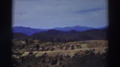 Truckee California (1937): Mountain Range With Road Running Through It And Trees