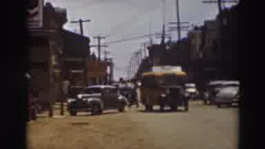 Truckee California (1937): School Bus Driving Down A Busy Street Avoiding Cars