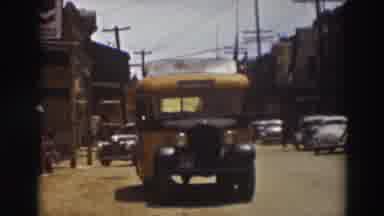 Truckee California (1937): View Of Yellow Bus And Parked Yellow Car On A Sunny Day