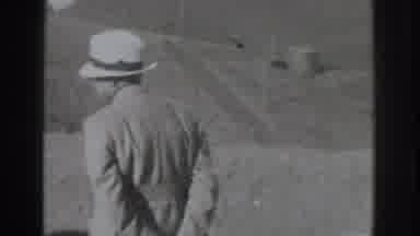 Vacaville California (1937): Man Wearing Black Suit Looks Through Binoculars On A