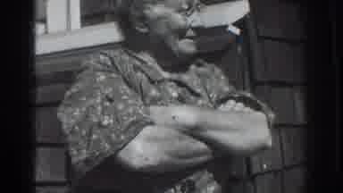 Vacaville California (1937): Woman Standing By White Door Points At Woman Wearing