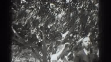 Vacaville California (1937): Man A Suit And Women In Dresses Sit Down Below A Tree