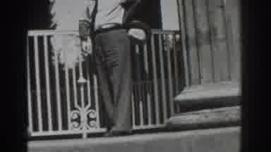 Vacaville California (1937): Man Wearing Grey Pants Walks Past Large Column