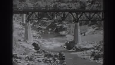 Oroville California (1938): A Railroad Bridge Spans Over A Swiftly Moving Rocky
