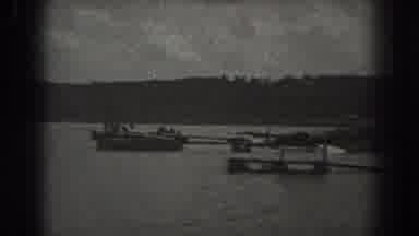 New Jersey (1938): Man Wearing Black Shorts Paddles On Board In Lake Water On A
