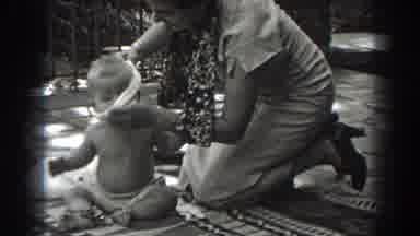 New Jersey (1938): Woman Wearing White Dress Removes White Shirt From Baby