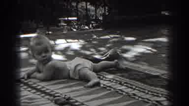 New Jersey (1938): Baby Attempting To Walk With Mom By His Side Outside