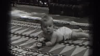 New Jersey (1938): Baby On Rug In Diaper Looking Around Playing With Toy