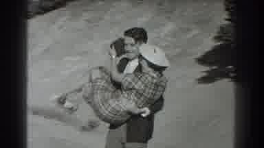 San Francisco California (1939): Man With Messy Hair Carrying Woman In Plaid Skirt