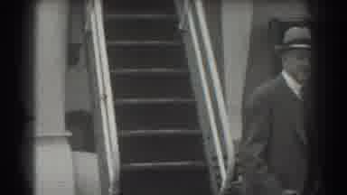 San Francisco California (1939): Man Wearing Dark Grey Suit Walks Past Light Grey