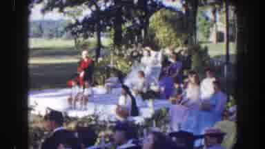 Florida (1941): People Sit In Open Air Park While Performance Is Made By Costumed