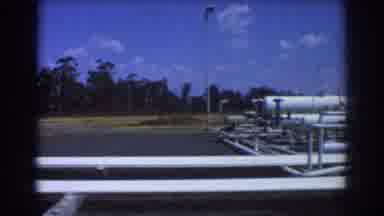 Brisbane Australia (1967): White Industrial Pipes And Equipment In Parking Lot