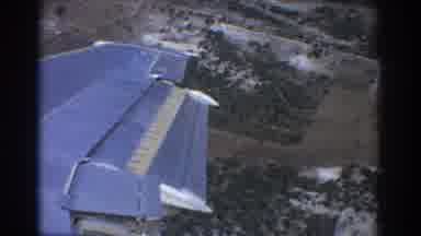 Perth Australia (1967): Blue Airplane Flying Over Open Field With Good Weather