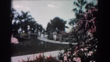 Florida (1957): People Walking On A Sidewalk Around Blooming Flowers And Trees