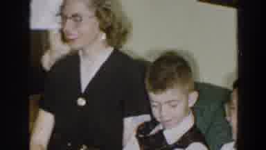 Wheeling Ohio (1957): Woman Wearing Black Dress Looks At Small Boy Wearing Black