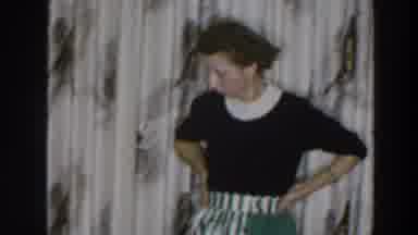 Wheeling Ohio (1957): Woman Wearing Black And White Dress Picks Up Object From