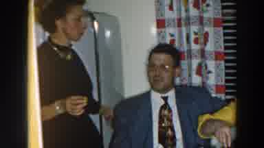 Wheeling Ohio (1957): Woman Wearing Yellow Dress Feeds Man Wearing Grey Suit And