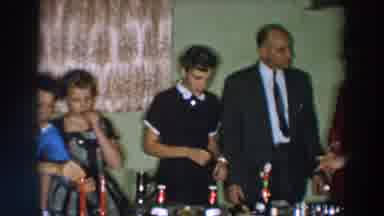 Wheeling Ohio (1957): Woman Wearing Black Dress Takes Small Food Item From Table