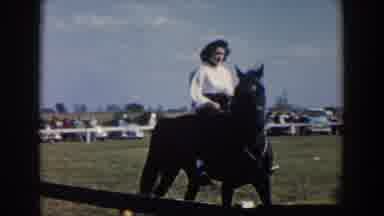 Wheeling Ohio (1957): Woman Wearing Blue Skirt Rides Side Saddle On Brown Horse On