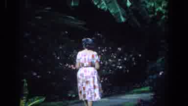 Florida (1958): Lady In White Print Dress Casually Strolls Down Garden Path