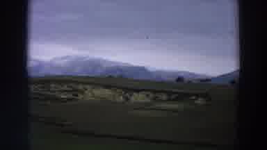 Italy (1958): View Of Snow Covered Mountains And Green Fields On A Cloudy Day