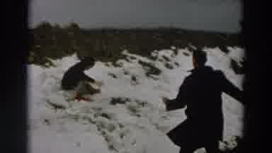 Italy (1958): Man Wearing Black Coat Plays In Snow With Child Wearing Black Coat