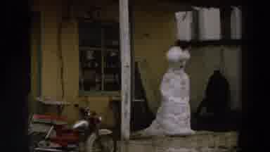 Italy (1958): View Of Mock Snowman In Front Of Yellow House On A Clear Day