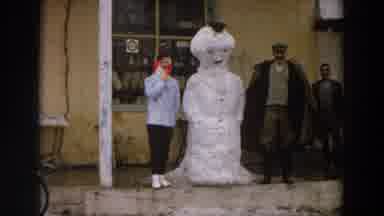 Italy (1958): Man Shaking Woman's Hand Opposite A Snowman In The Street