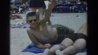 Yorktown Virginia (1958): Man Waves At Camera While Laying On Crowded Beach With