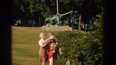 Florida (1959): Two Women Standing Behind Statue Wave At Camera On A Clear Sunny