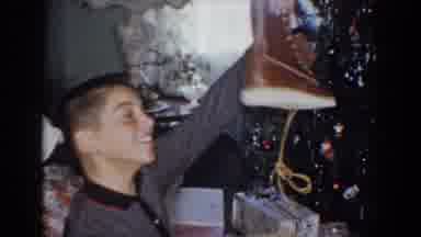 Bel Air Maryland (1960): Boy Wearing Grey Sweater Holds Up Brown Boot In Front Of