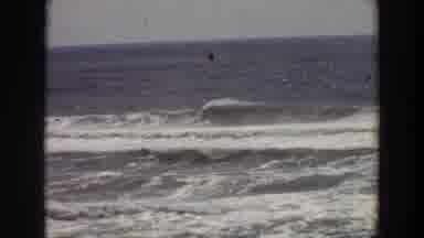 California (1964): Woman Shielding Sun While Watching Waves Roll In On Beach