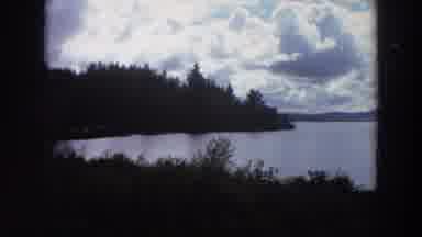 California (1964): Large Lake With Mountains Blue Sky And Clouds In The Background