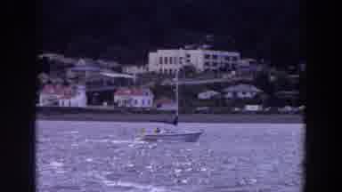 WASHINGTON-1964: A Sailboat Cruises East Along a Scenic Washington Shoreline