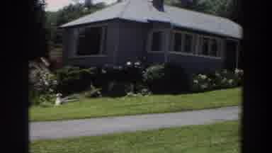 Washington (1964): Panning Shot Of Grey House With Garden In Front Yard And Narrow