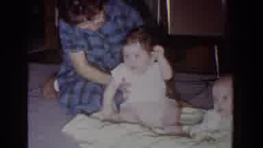Fallston Maryland (1965): Woman Wearing Blue Dress Helps Baby Wearing White Shirt