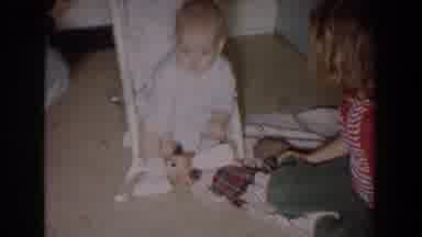 Fallston Maryland (1965): Child Plays With Baby In Rocker Chair Inside Room Woman
