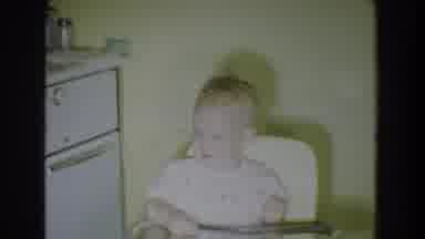 Fallston Maryland (1965): Baby Wearing White Shirt Sits In White Highchair Looking