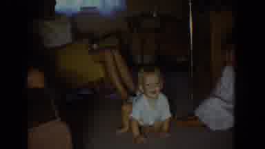 Fallston Maryland (1965): Baby Wearing White Shirt Crawls Past Toys On Tan