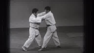 Tokyo Japan (1971): Two Men In Karate Suits With Locked Arms Stepping Back
