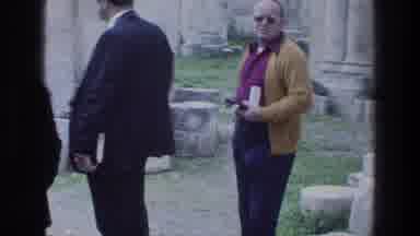 Jacobs Well Jerusalem Israel-1976: Woman Wearing Grey Coat Walks Past Red And White Columns