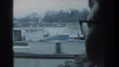 ZURICH SWITZERLAND-1976: A Woman Looking Out Of A Window Of A Moving Car At A Lake And Trolley Car