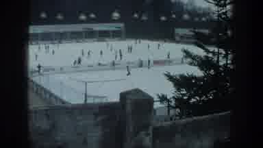 ZURICH SWITZERLAND-1976: Winter Ice Rink With Skaters And Pine Tree Foreground